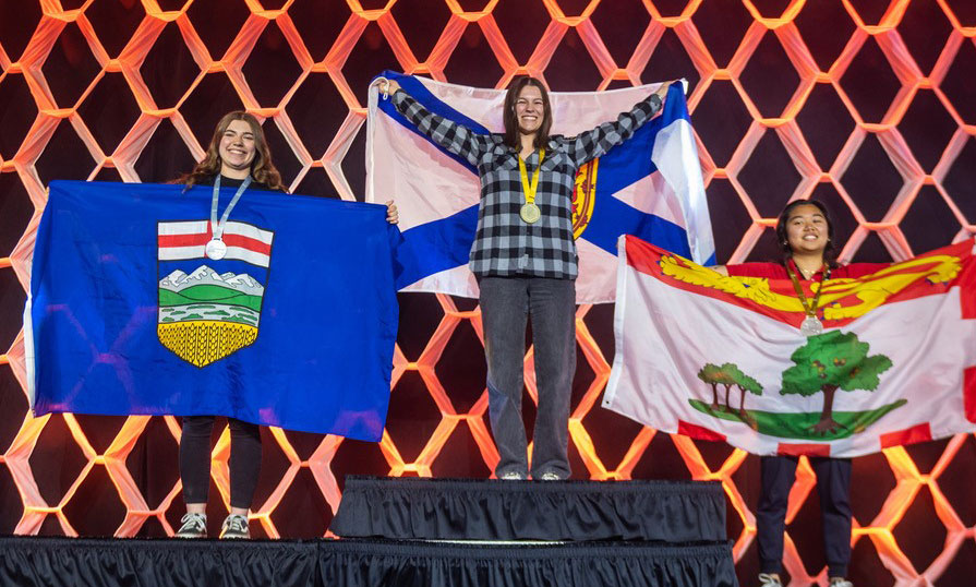 Olivia Sewell stands on the centre podium after winning a gold medal in the cooking contest during the Skills Canada National Competition in Winnipeg, Manitoba.