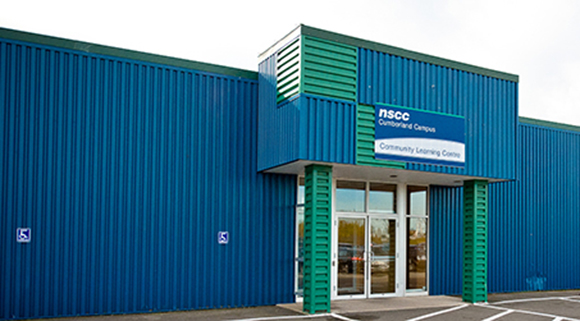 Exterior image of the Amherst Learning Centre which is a rectangular shaped building with blue aluminum siding and green trim with the NSCC sign above the front doors.