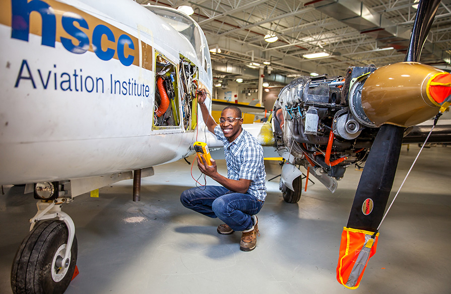 An Aircraft Maintenance Engineering student working on an aircraft.