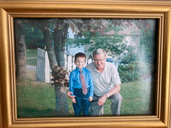 Framed photo of Ross Marshall and his grandson after his preschool graduation.