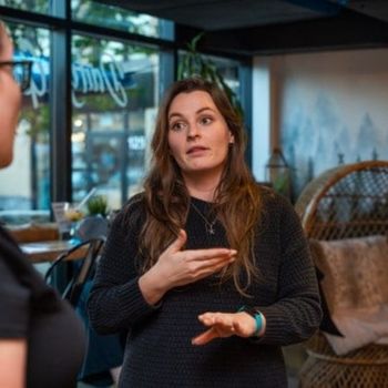A woman using ASL while speaking to another person.