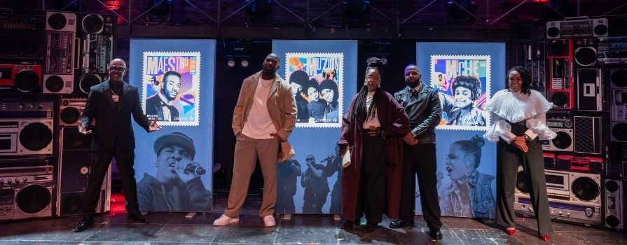 Three men and two women are posing on stage.
