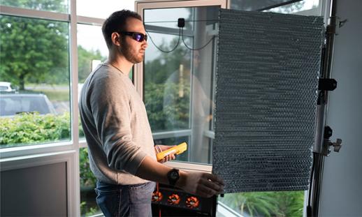 Cole Gregory is wearing sunglasses while using equipment in a lab.