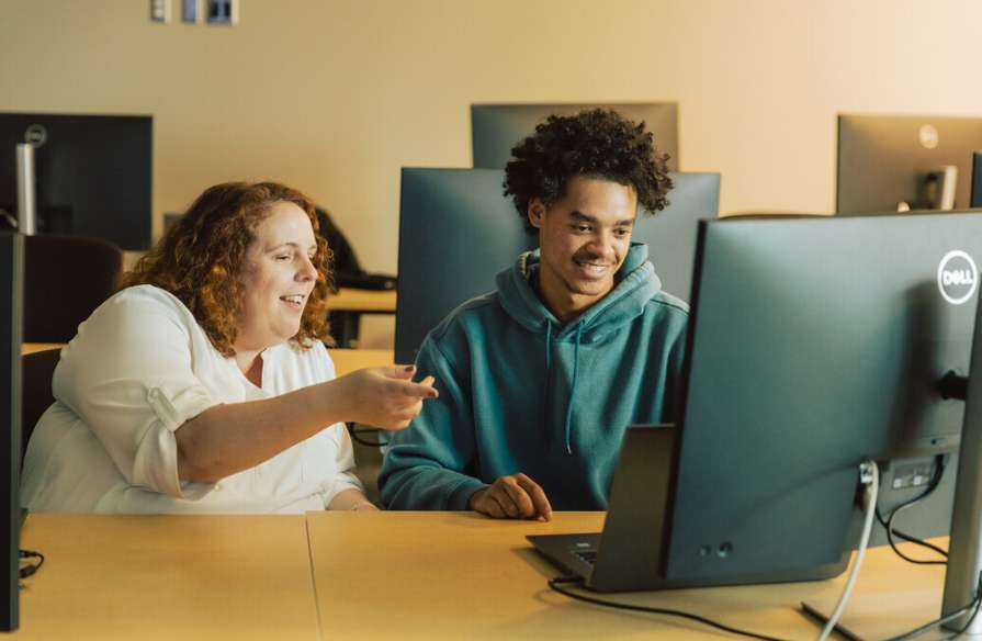 Photo of NSCC students working together on a computer.