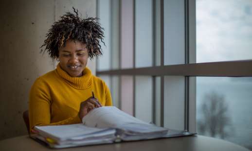 Photo of Black NSCC student studying by window.