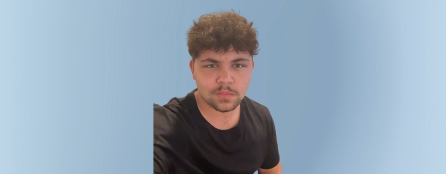 Photo of Treysyn in front of a faded blue background.