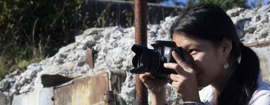 Photo of Amber H. taking a photo with her camera outside.