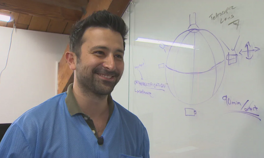 Arad Gharagozli in front of a white board with a diagram and calculations.