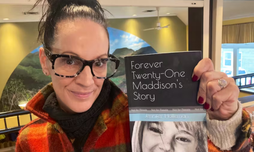 Jennifer Holleman holding her book that she wrote about her late daughter, titled "Forever Twenty-One Maddison's Story".