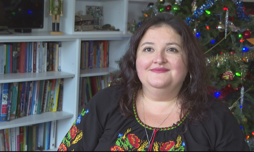 Olesya Shyvikova sitting in her living room during the holiday season. 