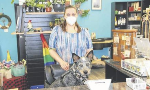 Mercedes Blair and her dog Izzy behind the counter of her business, Wandering Jasmine Gardens.