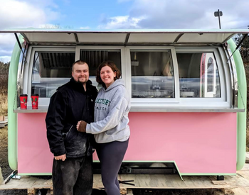 Liam Crane and Ashley Scott in front of their pink food trailer.