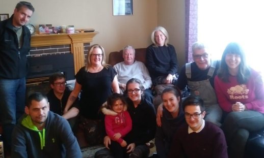 Photo of the Marshall family by a fireplace.