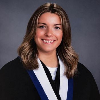 A white woman wearing her graduation gown in her grad photo.