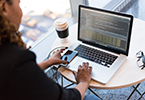 Photo of person on laptop with coffee