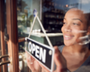 Photo of woman changing window sign to open