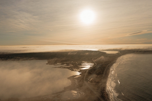 Aerial drone photography of a misty morning sunrise over Lawrencetown beach.