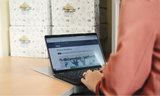 Woman on a laptop looking at the Alumni website.