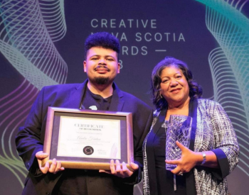 Andre Fenton and  Juanita Peters on stage holding their Creative Nova Scotia Awards.