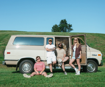 Good Dear Good band members in front of a retro van in a field on a sunny day.