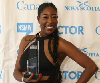 Jah'Mila holding one of her awards in front of a Music Nova Scotia backdrop.