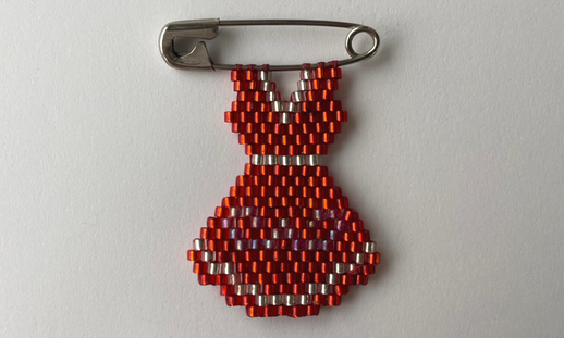 Beaded red dress on a safety pin.