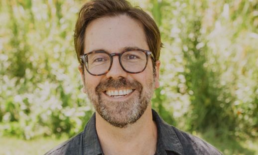 A headshot of Tom Ryan in front of trees.