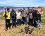 A group of researchers standing on a coastline with field research equipment.