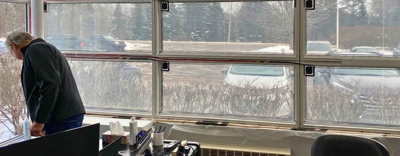 Interior view of office windows with photovoltaic film and wiring subtly integrated around the edges.