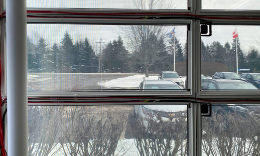 Interior view of office windows with photovoltaic film and wiring subtly integrated around the edges.
