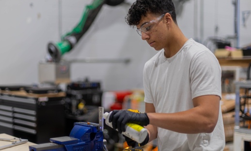 Student working hands-on with a piece of technology in a workshop setting.