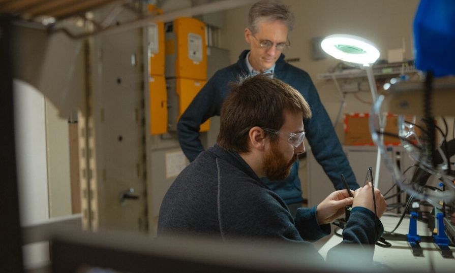 Two people working in a technology lab with electronic equipment.
