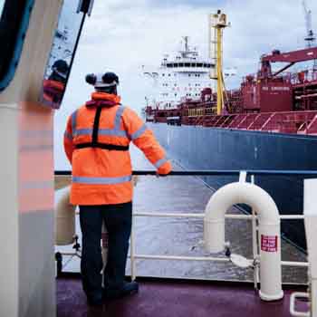 man standing on ship facing away from camera