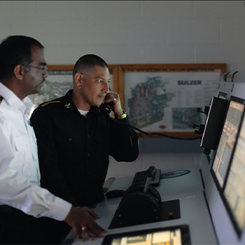 Two men standing in a simulator, one is holding a phone