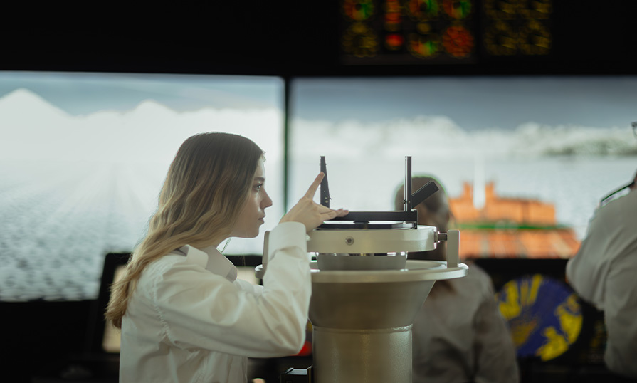 Julianna Lucic on a simulated deck looking through a navigation device