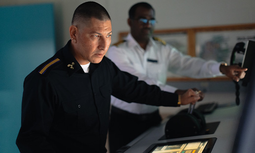 A Marine Engineering Management Technology student and instructor in using an engine room simulator