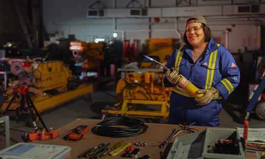 Marine Engineering Technology student Michaela Julian in the engine shop holding a welding torch