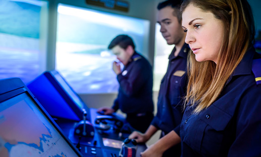 Marine students on a ship looking at a screen