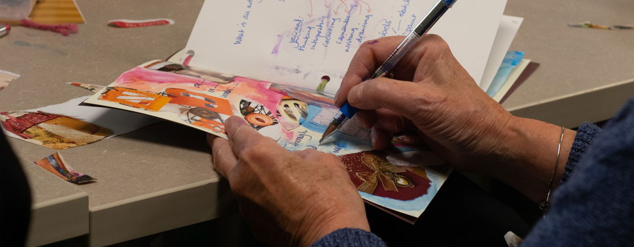 Workshop participant creating an journal page in a hands on wellness workshop.