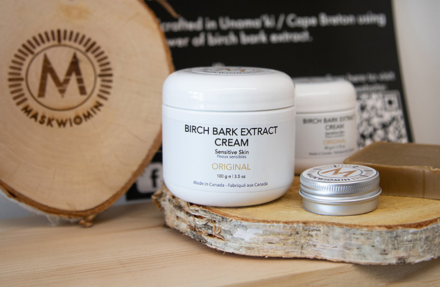 A collection of birch bark skincare products on a piece of cut birch.