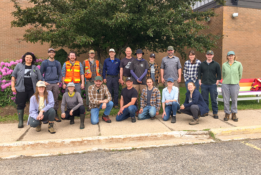 A group of forestry students stands on the sidewalk