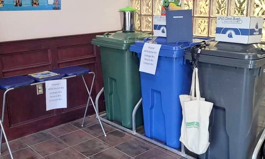 A waste sorting station with garbage bags and other supplies.