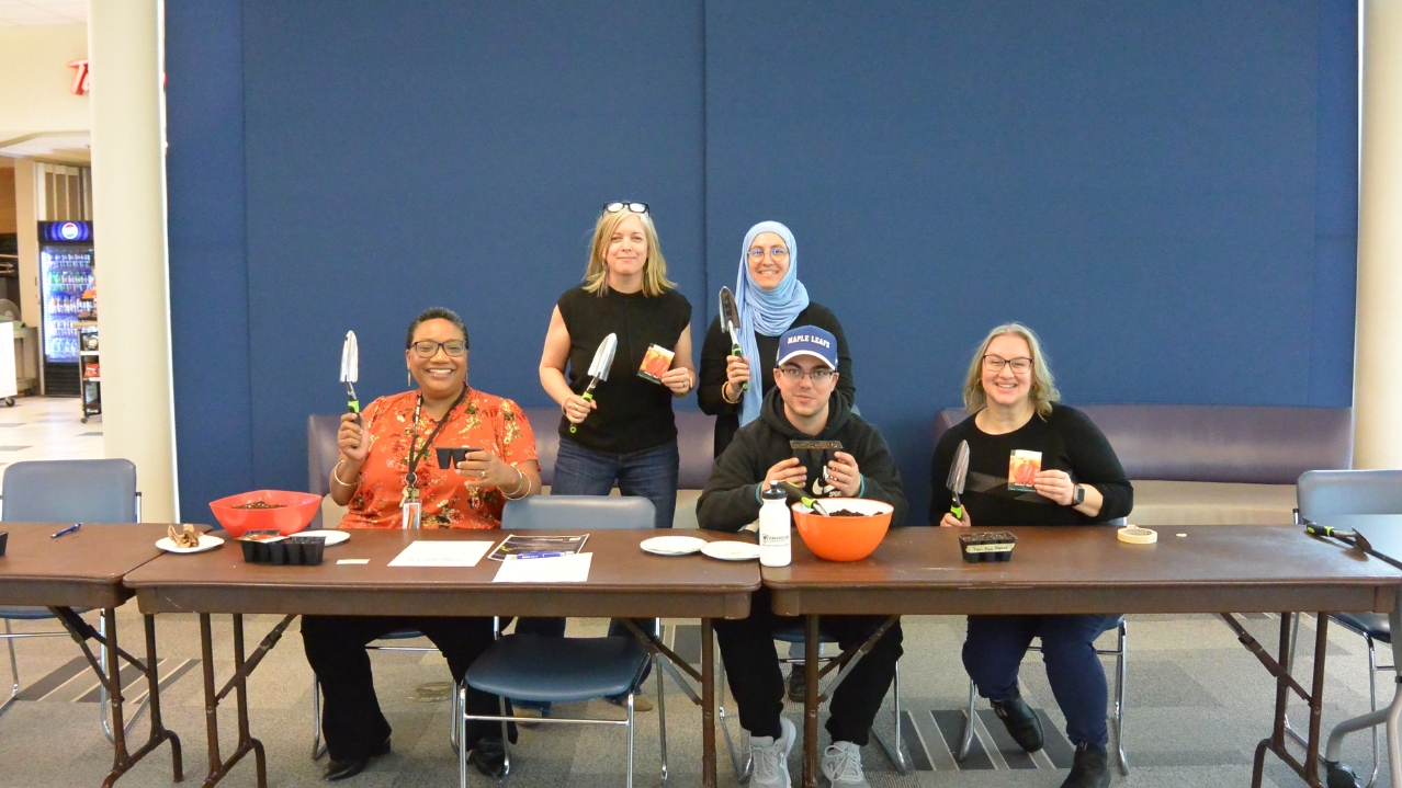 Photo of NSCC employee and student volunteers planting the first seeds for Iga'taqan.