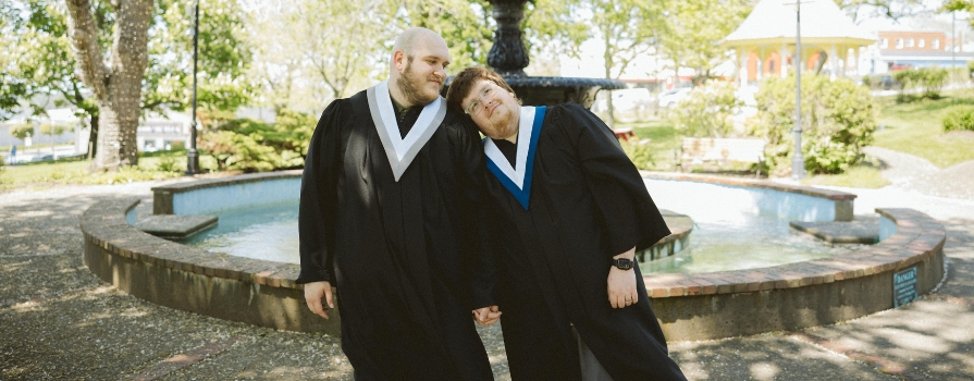 From left to right: Dustin and Zach in their convocations in front of the Frost Park Fountain in Yarmouth.