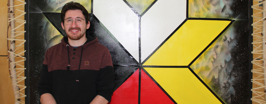 Andrew M. standing in front of the Mi'kmaq eight-pointed star.