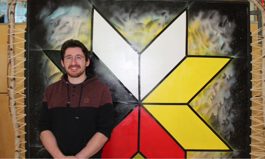 Andrew M. standing in front of the Mi'kmaq eight-pointed star.