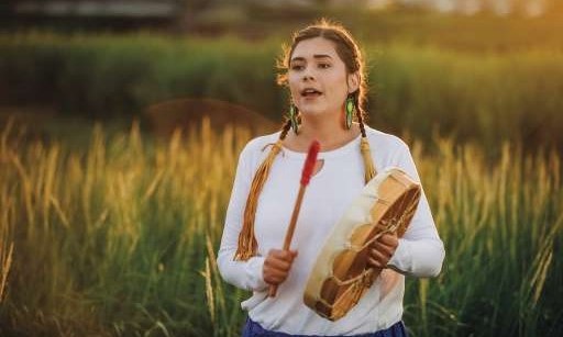 Indigenous student playing the drum