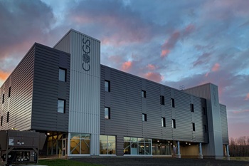 The outside of the COGS campus housing building set against a vibrant sunset.