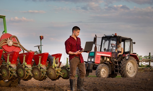 Farmer standing in a field with a tablet computer