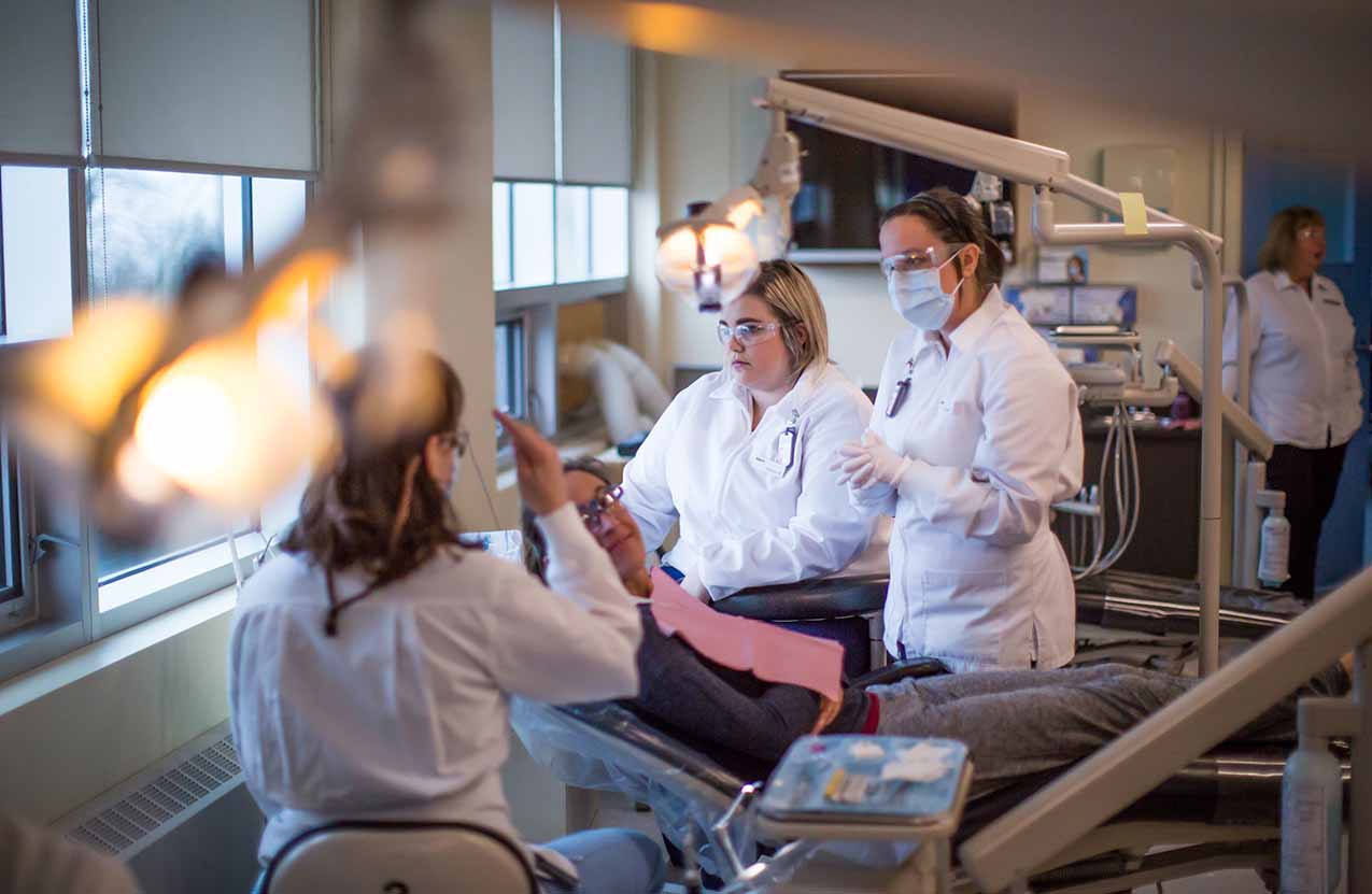 Faculty teach students in the dental assisting lab.